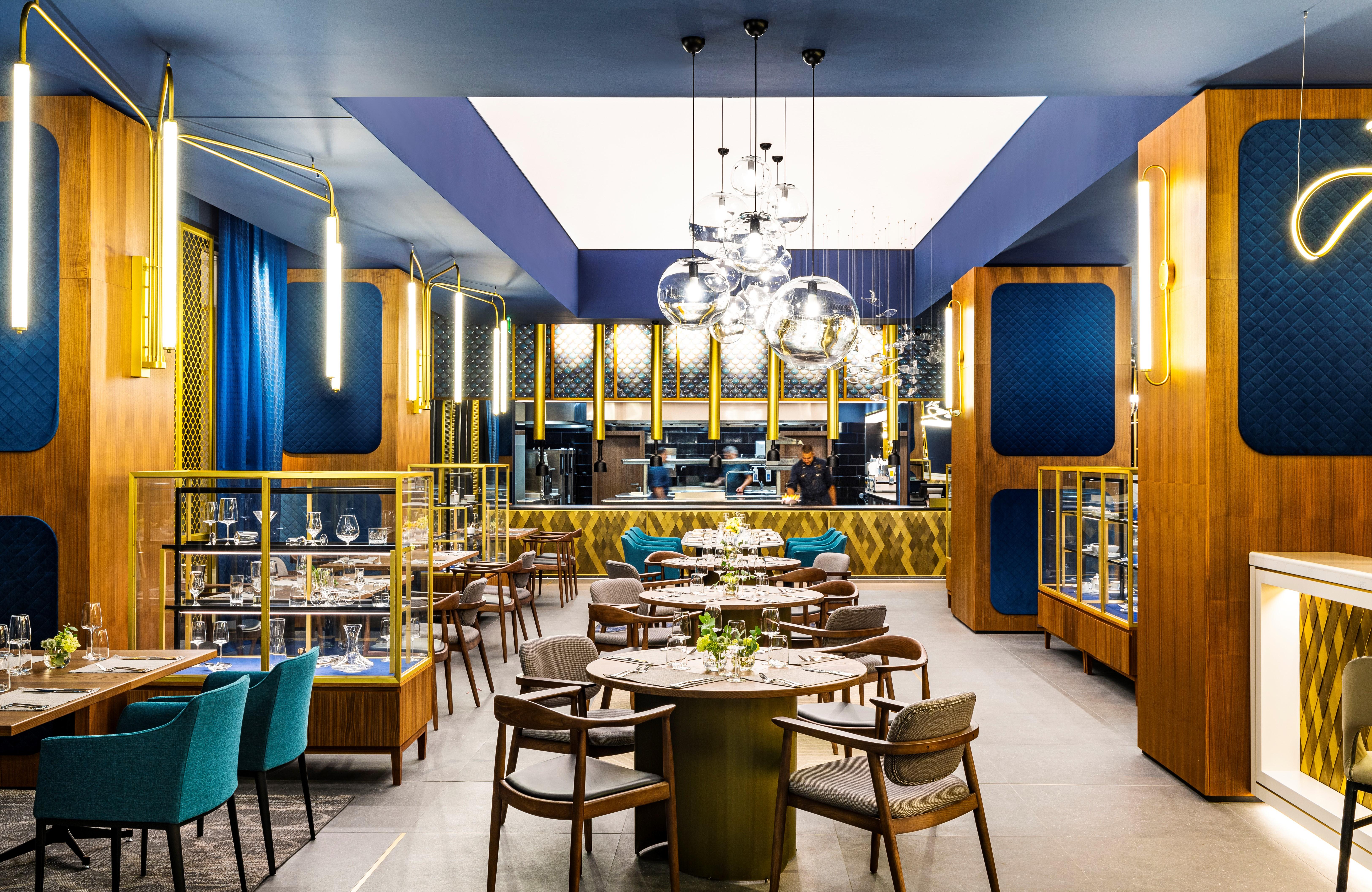 Grand Hotel Millennium Sofia Exterior photo The photo depicts a modern restaurant interior characterized by sleek and elegant design elements. The space features wooden accents, with warm tones creating an inviting atmosphere. 

Tables are arranged centrally, surrounded by comfortable upholste